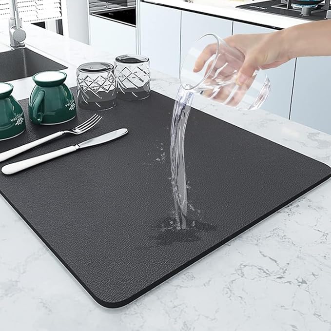 Water being poured onto a black quick dry kitchen mat to demonstrate absorption